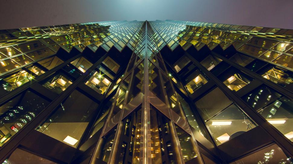 Free Image of Skyscraper s geometric glass facade at night 