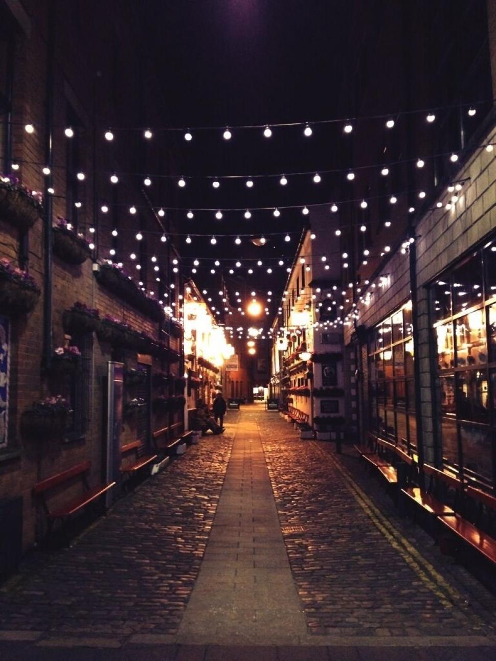 Free Image of Twinkling lights along an urban alley at night 