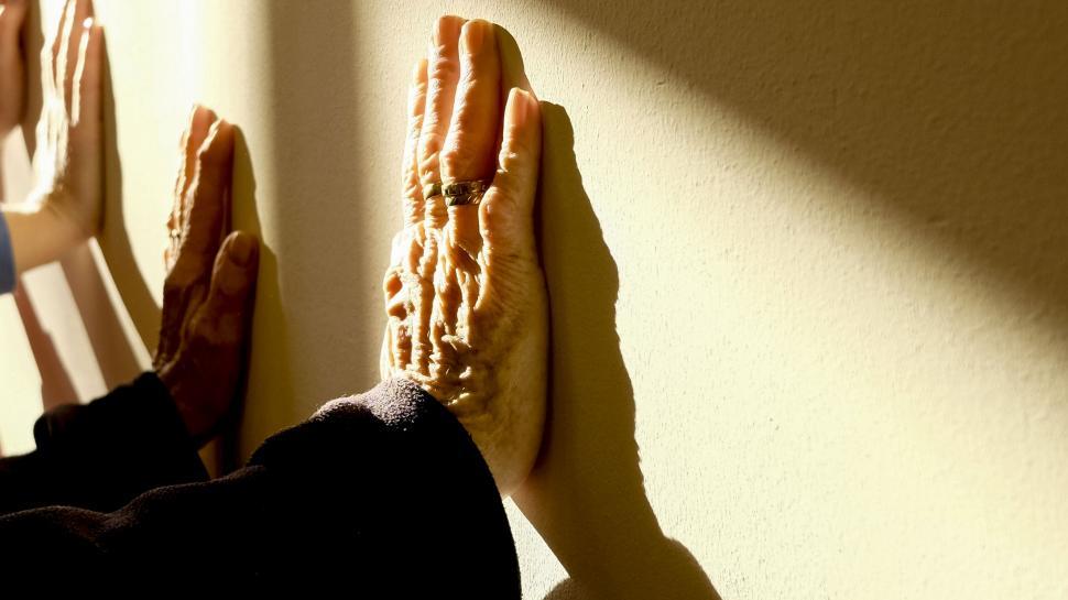 Free Image of Hands pressed against sunlit wall in warmth 