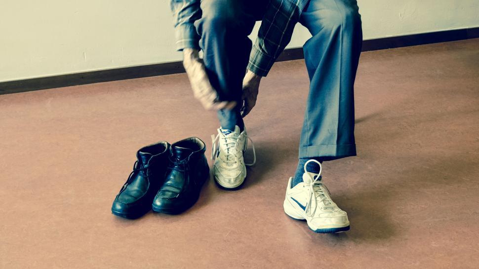 Free Image of Man switching shoes in a colorful setting 