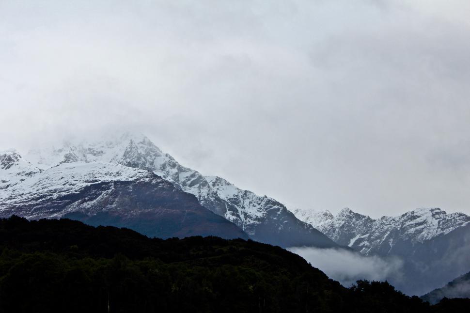 Free Image of Forested mountain peaks shrouded by clouds 