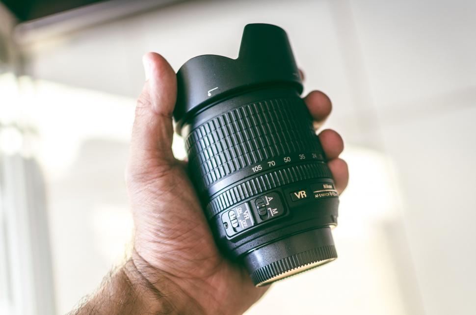 Free Image of Hand holding a DSLR camera lens 