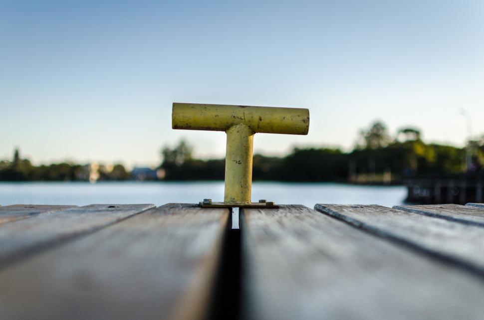 Free Image of Yellow mooring bollard with water background 