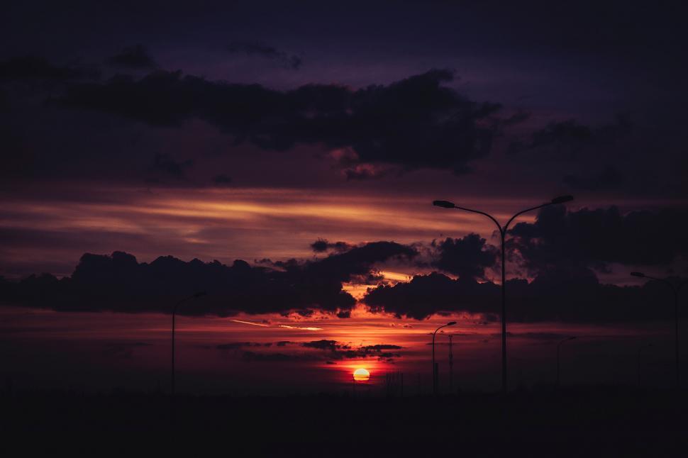 Free Image of Dramatic Sunset with Streetlights and Clouds 
