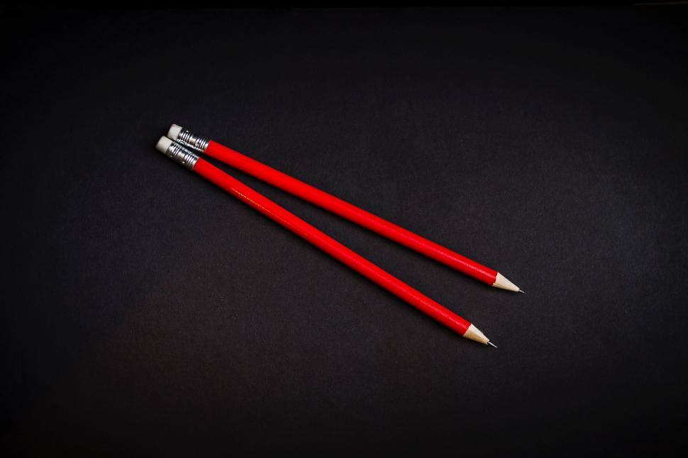 Free Image of Two red pencils on a black background 