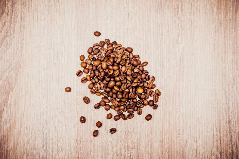 Free Image of Scattered coffee beans on wooden surface 