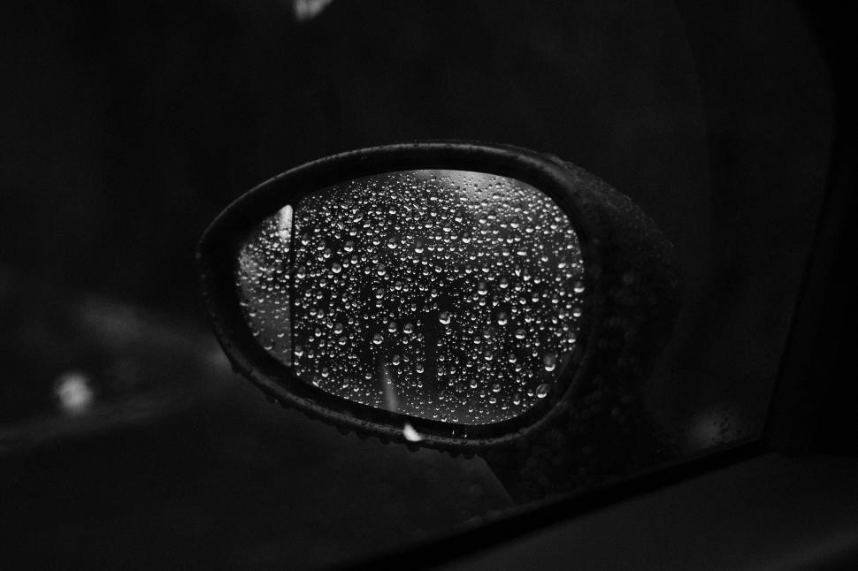 Free Image of Rain drops on car side mirror in BW 