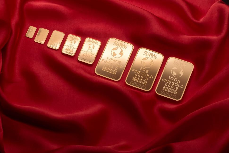 Free Image of Gold bars lined up on rich red satin 