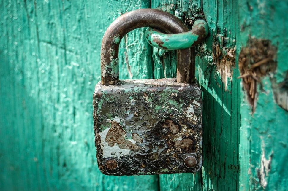 Free Image of Old rusty padlock on a weathered green door 