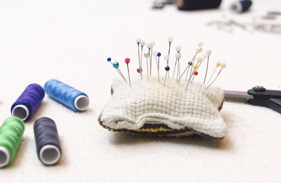 Free Image of Sewing needles on a pincushion with threads 