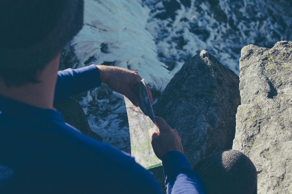 Free Image of Hiker reading a map on mountain top 