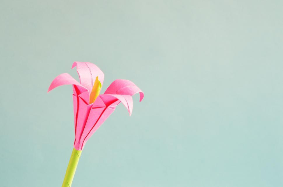Free Image of Pink origami crane on blue background 