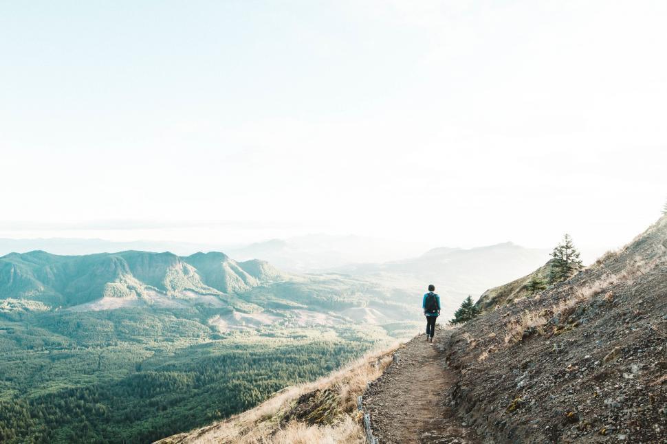 Free Image of Hiker on a mountain trail at sunset 