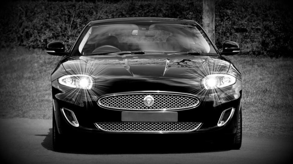 Free Image of Black Jaguar car front with glowing headlights 