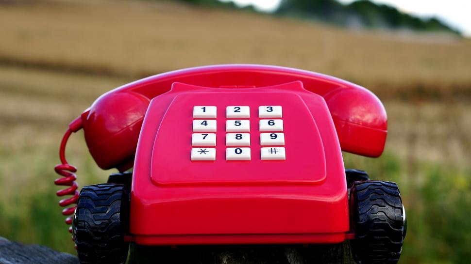 Free Image of Retro red telephone on a wooden post 