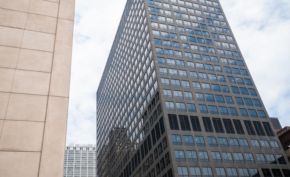 Free Image of Low angle view of a towering glass building 