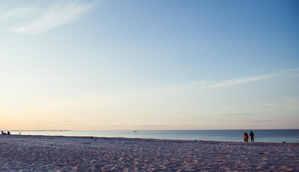 Free Image of Silhouette of two people walking on the beach 