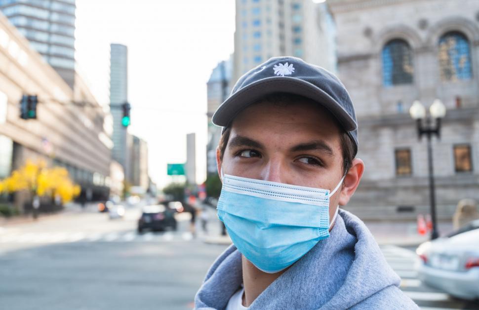 Free Image of Person in hoodie standing on city street 