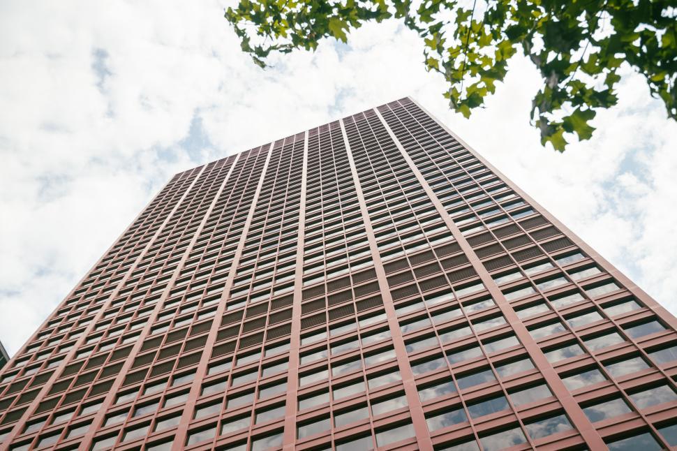 Free Image of Towering red skyscraper reaching into the sky 