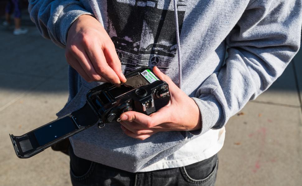 Free Image of Close-up of hands loading film into camera 
