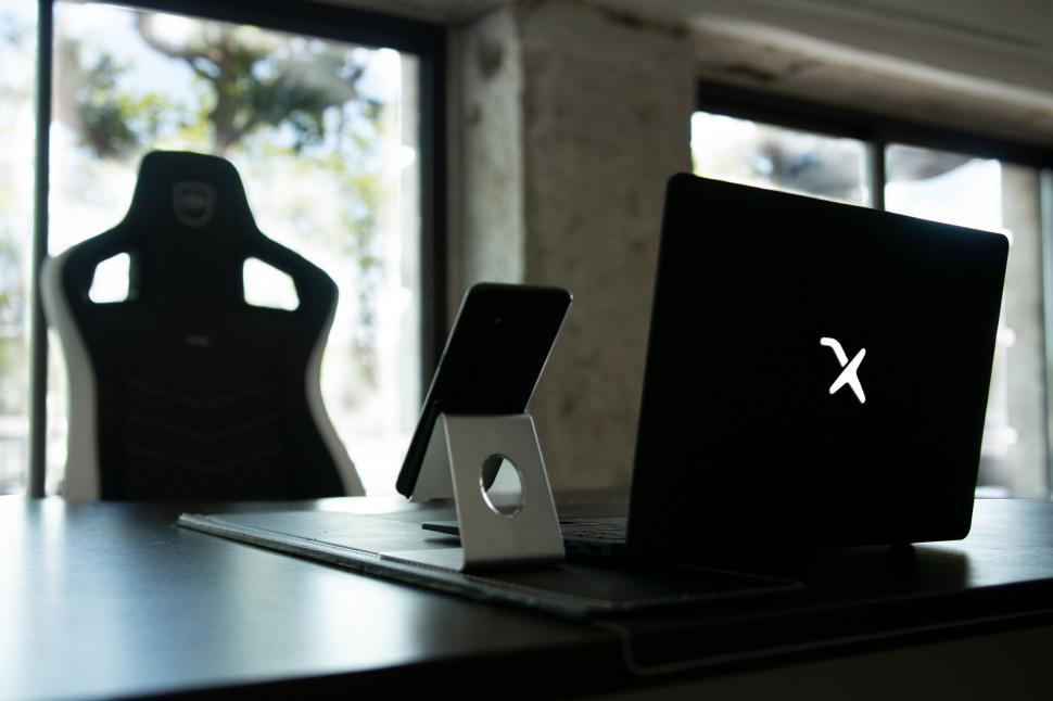 Free Image of Laptop and smartphone setup with racing chair 