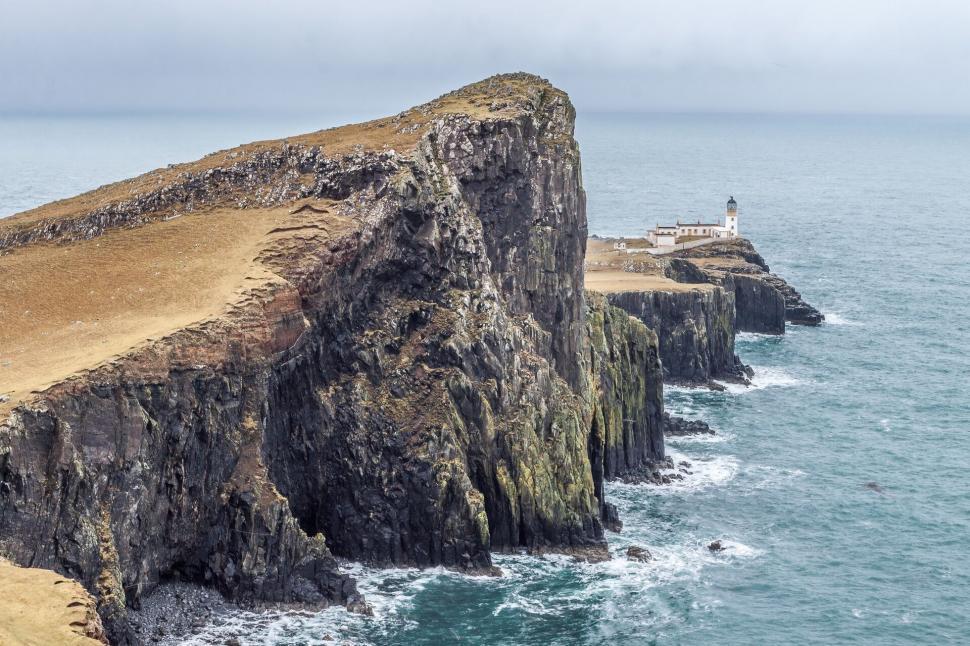 Free Image of Rustic lighthouse atop rugged coastal cliffs 