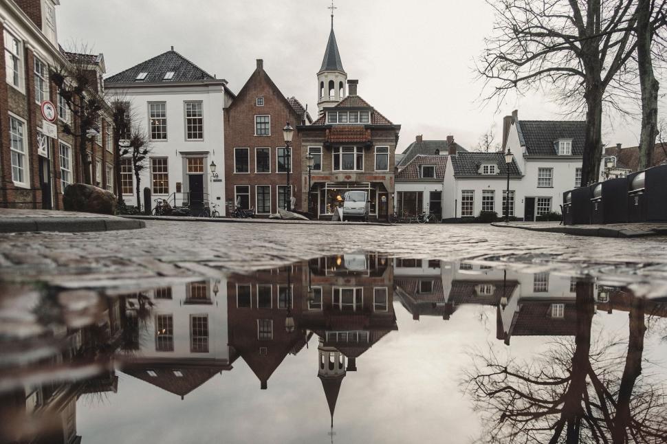 Free Image of Reflection of buildings and church in water puddle 