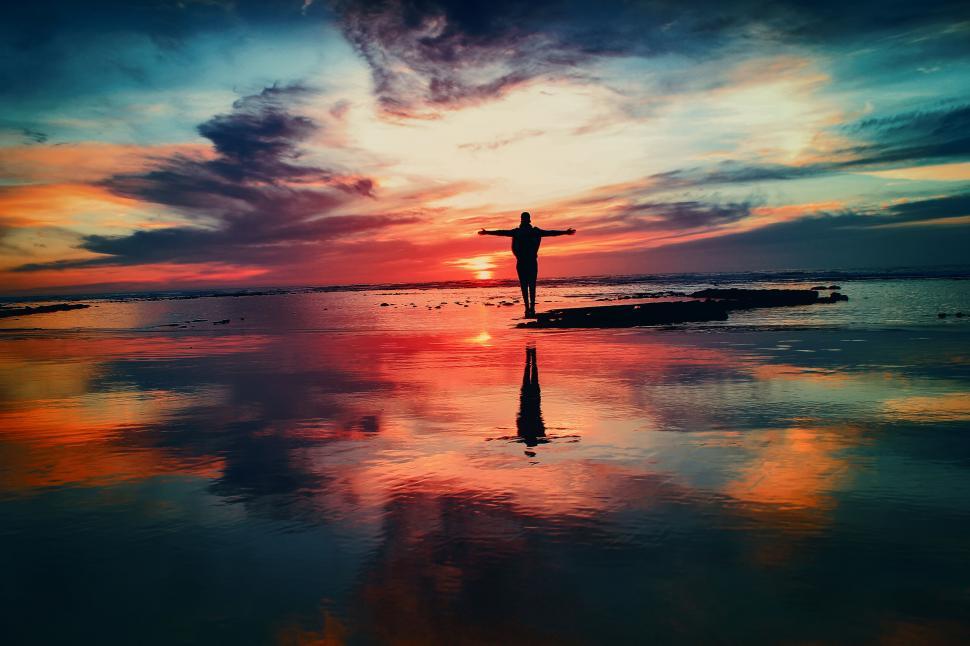 Free Image of Person standing in shallow waters at dusk 