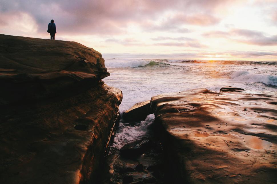 Free Image of Solitary figure on a cliff at sunset 