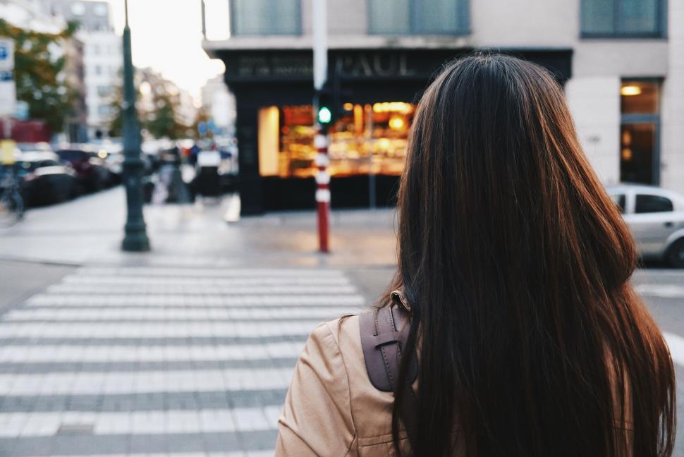 Free Image of Woman walking towards bakery shop at dusk 