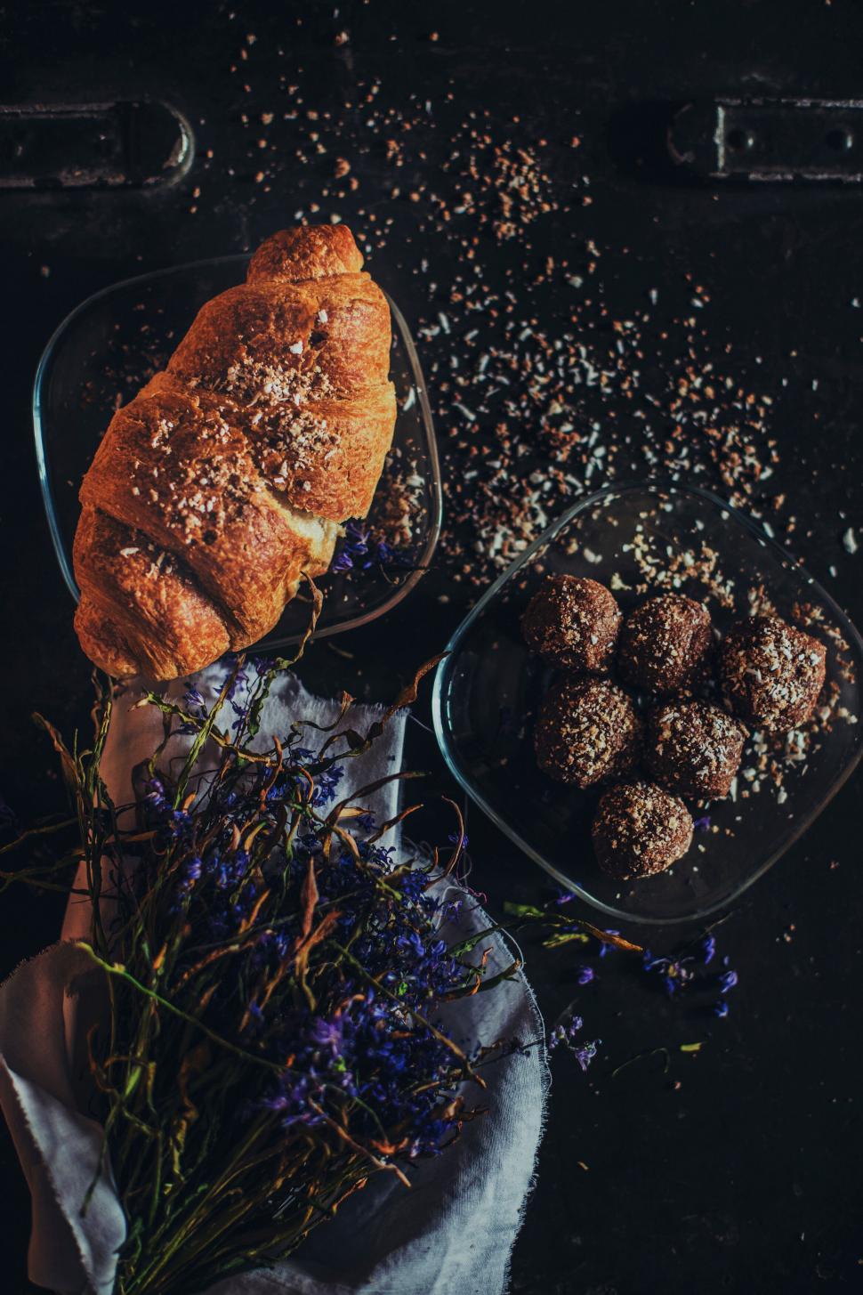 Free Image of Fresh croissant and chocolate balls on dark table 