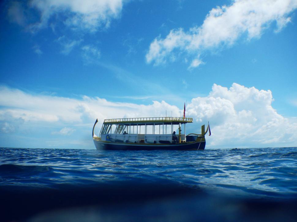 Free Image of Boat floating on a calm blue ocean 