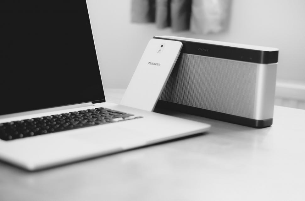 Free Image of Laptop and speaker on a desk in grayscale 