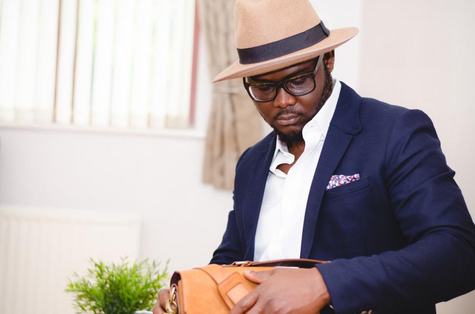 Free Image of Businessman checking contents of leather bag 