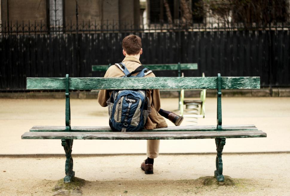 Free Image of Man sitting alone on park bench from behind 