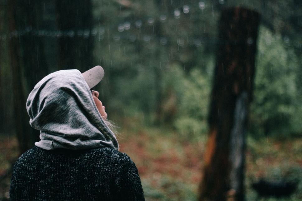 Free Image of Woman in hoodie enjoying the rain in forest 