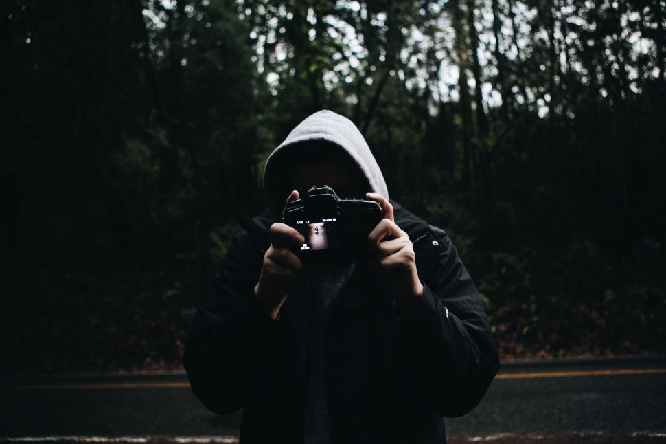 Free Image of Photographer holding a camera in a wooded area 