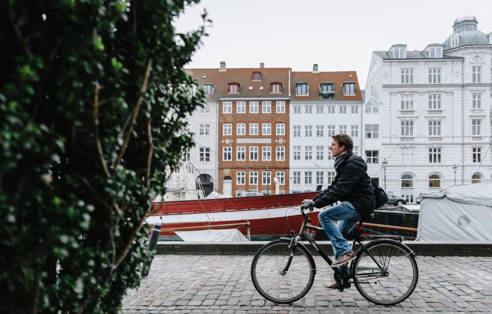 Free Image of Man cycling past historical European buildings 