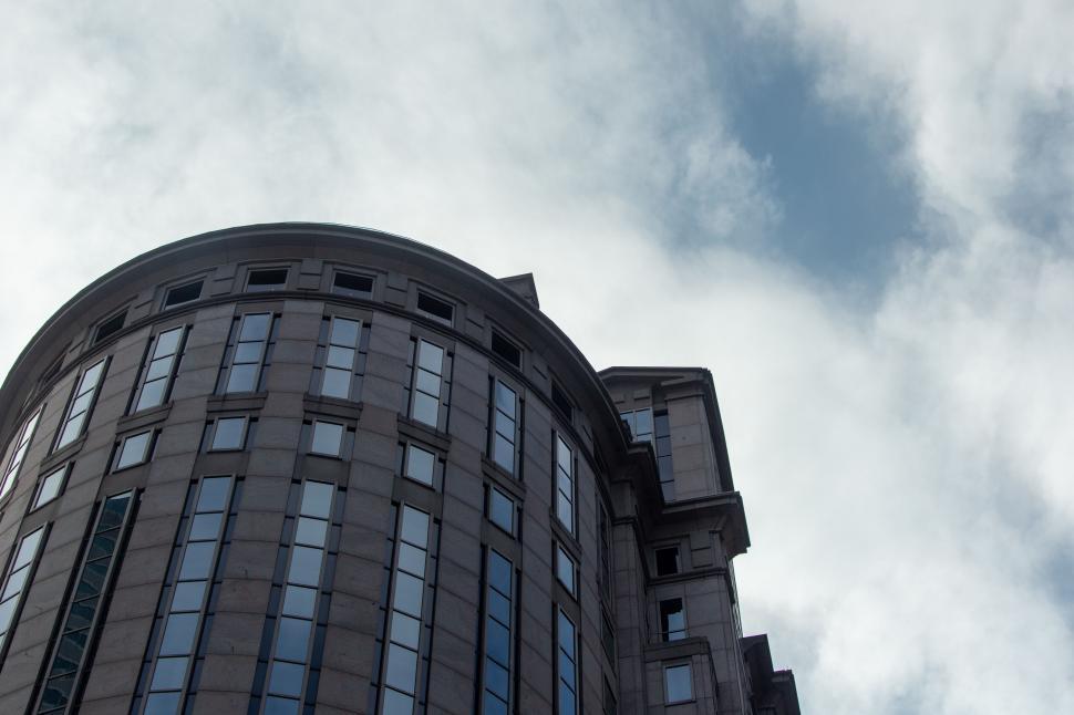 Free Image of Clouds over modern building with curved facade 