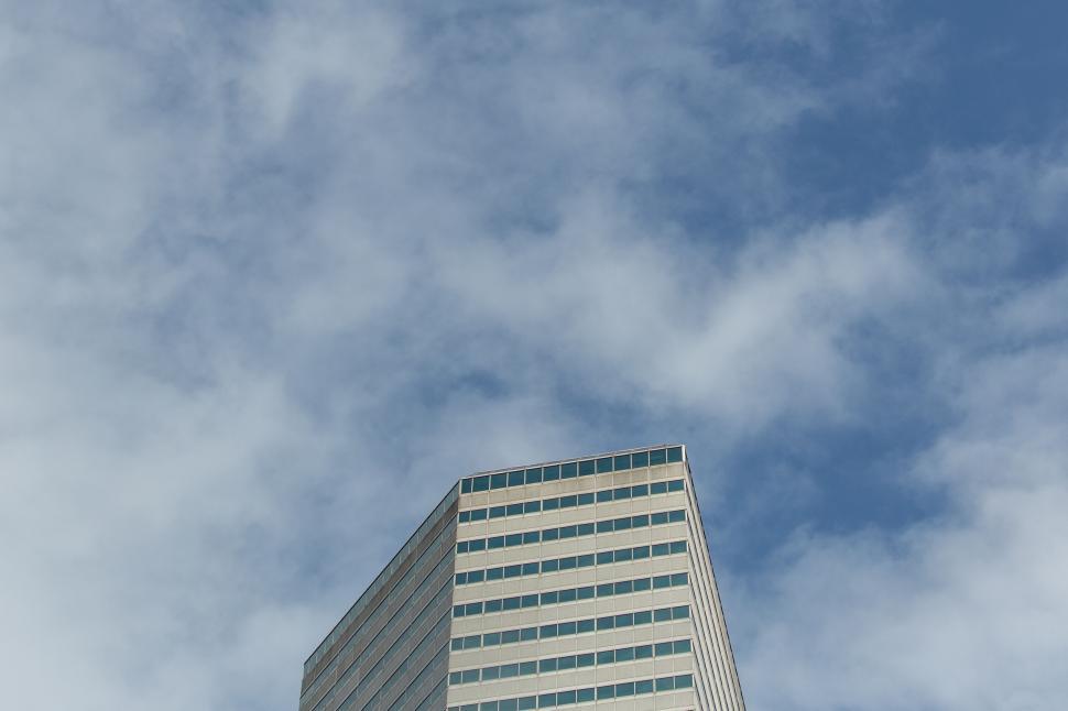 Free Image of Modern skyscraper touching cloudy sky 