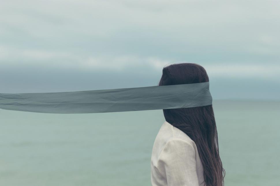 Free Image of Woman with cloth over face by sea 