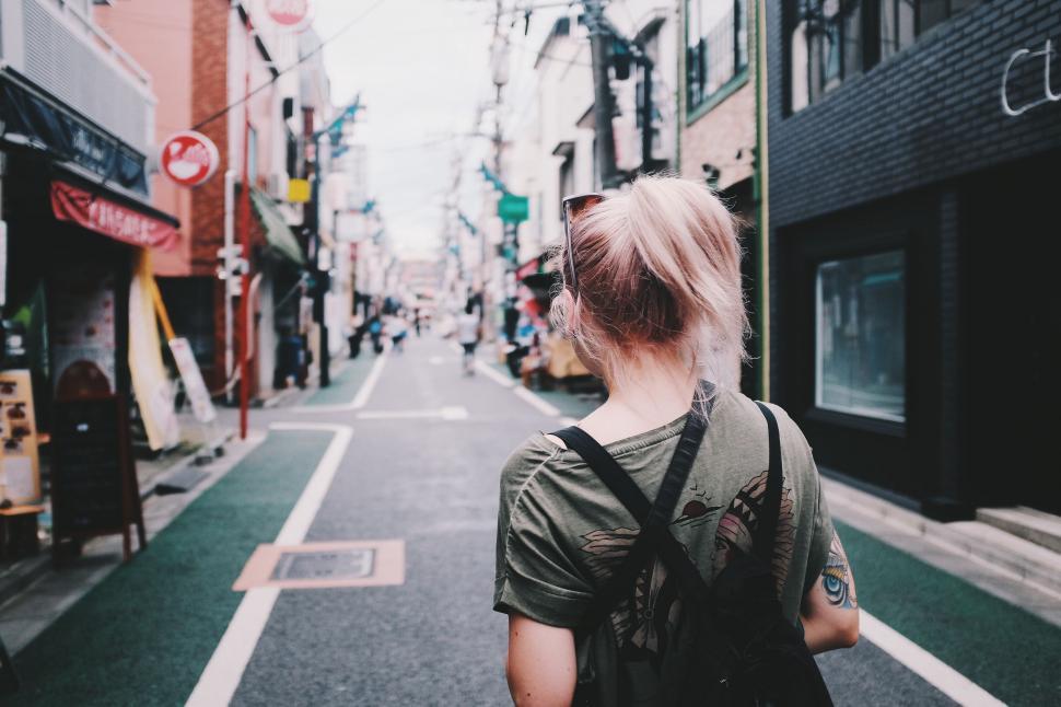 Free Image of Blonde woman exploring quiet Japanese street 