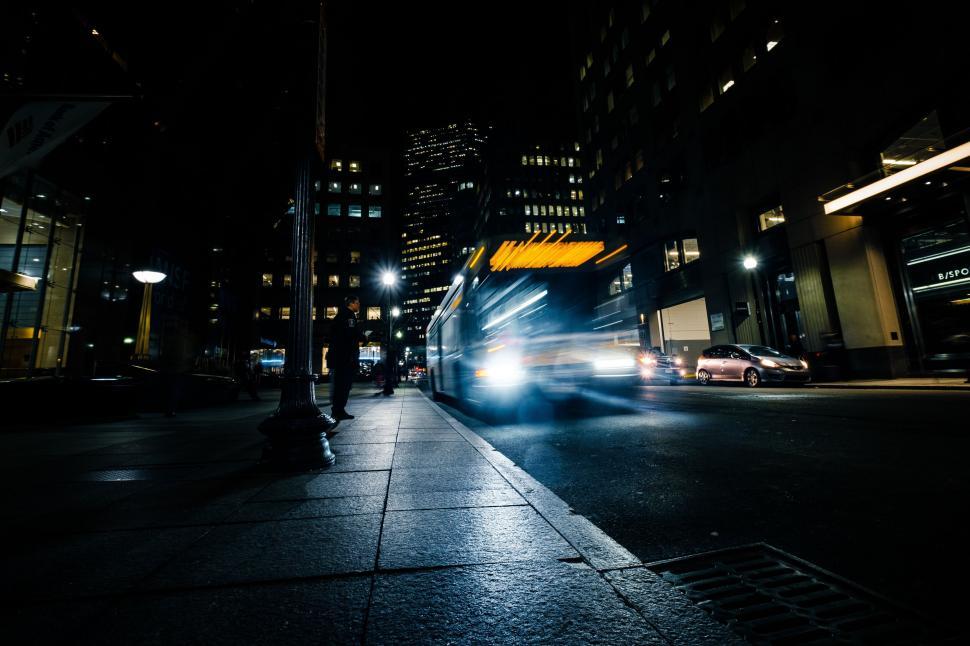 Free Image of Night street scene with motion-blurred vehicle 