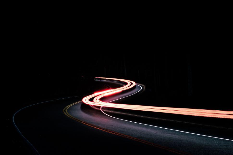 Free Image of Curving road with light trails at night 