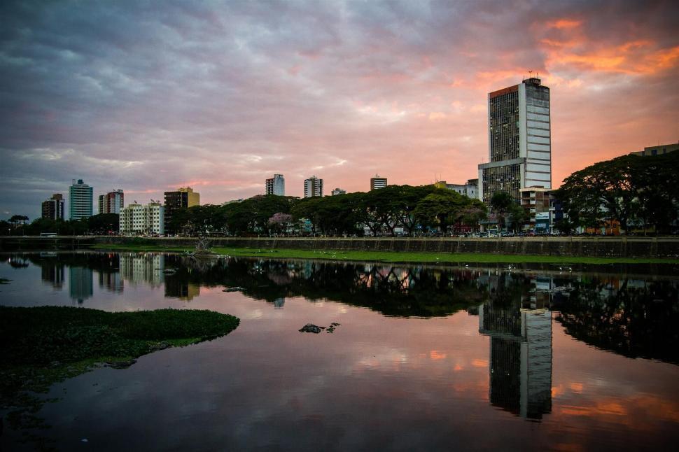 Free Image of Cityscape reflected on water at sunset 
