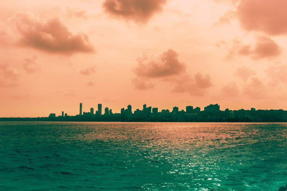 Free Image of Vibrant sunset over silhouette city skyline 