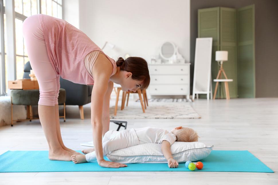 Free Image of Mother gently bends over to help sleeping child 