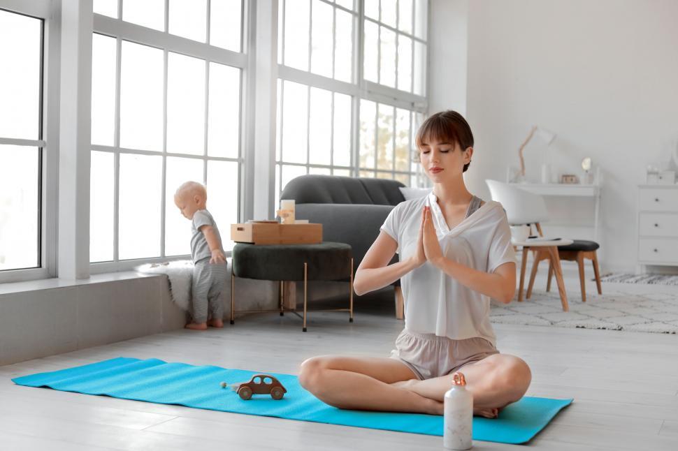 Free Image of Woman meditating while child explores background 