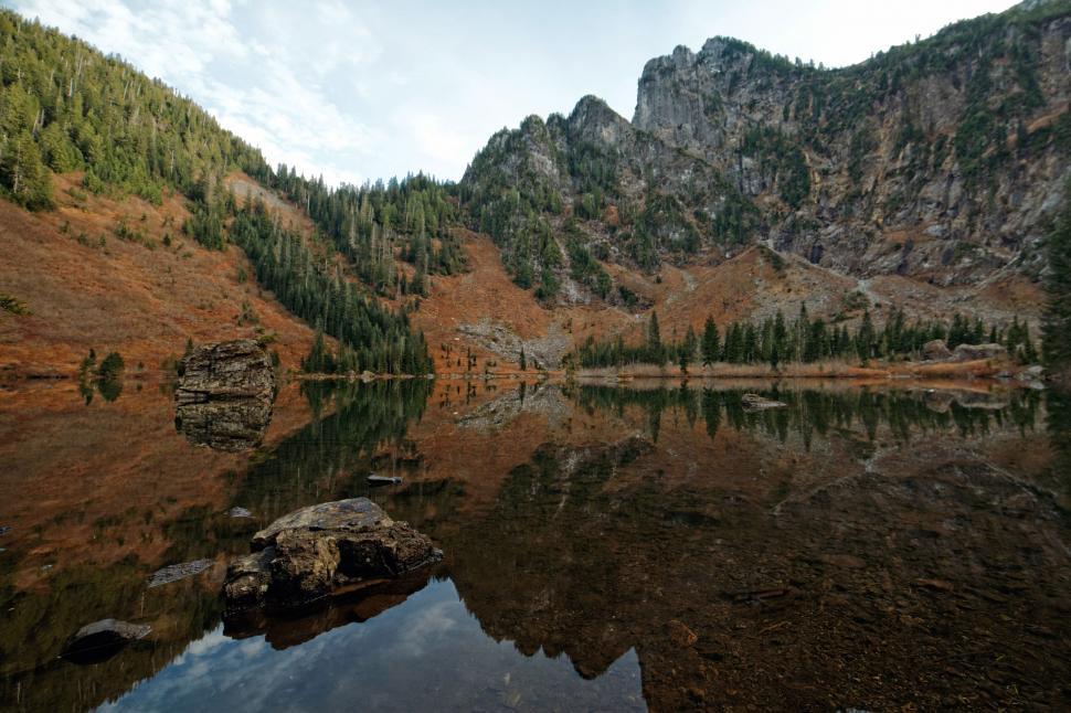 Free Image of Mirror-like reflection on a serene mountain lake 