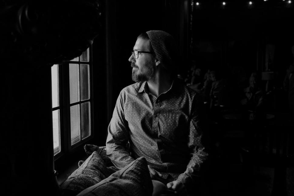 Free Image of Monochrome portrait of a person by window 